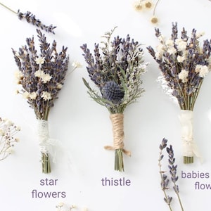 May include: Three small bouquets of dried flowers, each tied with a different ribbon. The bouquets are labeled "star flowers", "thistle", and "babies breath flowers".