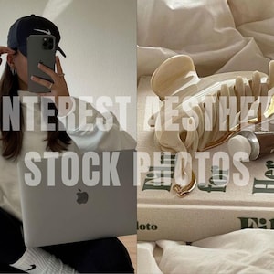 May include: A white sweatshirt with a black baseball cap and a silver laptop. The laptop is open and the screen is showing a white background. The person is sitting on a white surface. The image is a Pinterest aesthetic stock photo.