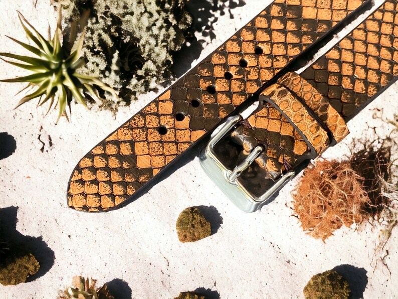 May include: A brown leather watch strap with a snakeskin pattern and a silver buckle.