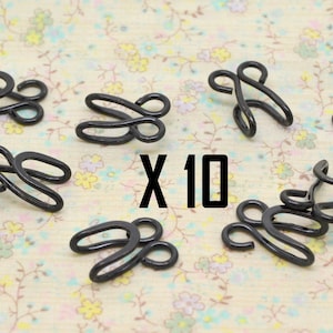 Peut inclure: Dix fermoirs à crochet et à œil en métal noir pour des projets de couture. Les crochets et les œillets sont conçus pour être utilisés pour les vêtements, les sacs ou d'autres projets où une fermeture sécurisée est nécessaire.
