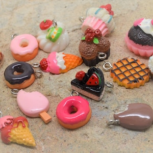 Puede incluir: Surtido de encantos de comida en miniatura de colores, que incluyen donas, cupcakes, conos de helado y una galleta. Los encantos están hechos de arcilla polimérica y tienen un acabado brillante.