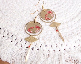 May include: Gold earrings featuring a floral design and a hammered metal pendant. The earrings are delicate and feminine in style.