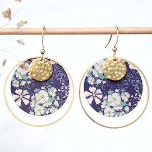 Peut inclure: Une paire de boucles d'oreilles créoles dorées avec un cercle à motif floral et un cercle en or martelé suspendu à chaque créole.