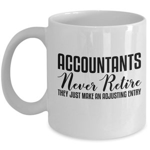 May include: White ceramic coffee mug with a black design that reads "Accountants Never Retire They Just Make An Adjusting Entry".