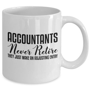May include: White ceramic coffee mug with black text that reads "Accountants Never Retire They Just Make An Adjusting Entry".