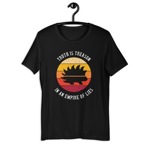 May include: Black t-shirt featuring a vintage-style graphic of a porcupine in a circle with the text "Truth is Treason in an Empire of Lies".