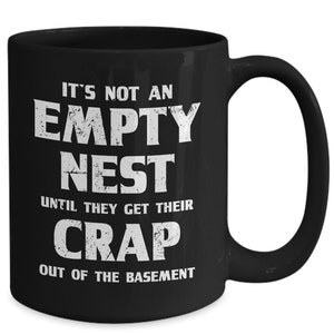 Pode incluir: Caneca de caf&eacute; de cer&acirc;mica preta com texto branco. O texto diz: "N&Atilde;O &Eacute; UM NINHO VAZIO AT&Eacute; QUE ELES TIREM SUA MERDA DO POR&Atilde;O."
