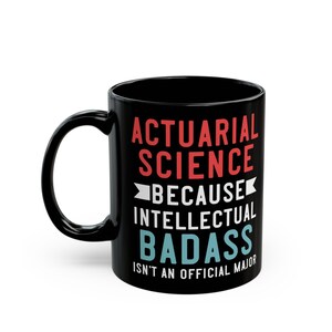 Peut inclure: Mug en céramique noire avec le texte "ACTUARIAL SCIENCE BECAUSE INTELLECTUAL BADASS ISN'T AN OFFICIAL MAJOR" en rouge, blanc et bleu. La tasse a une anse incurvée.