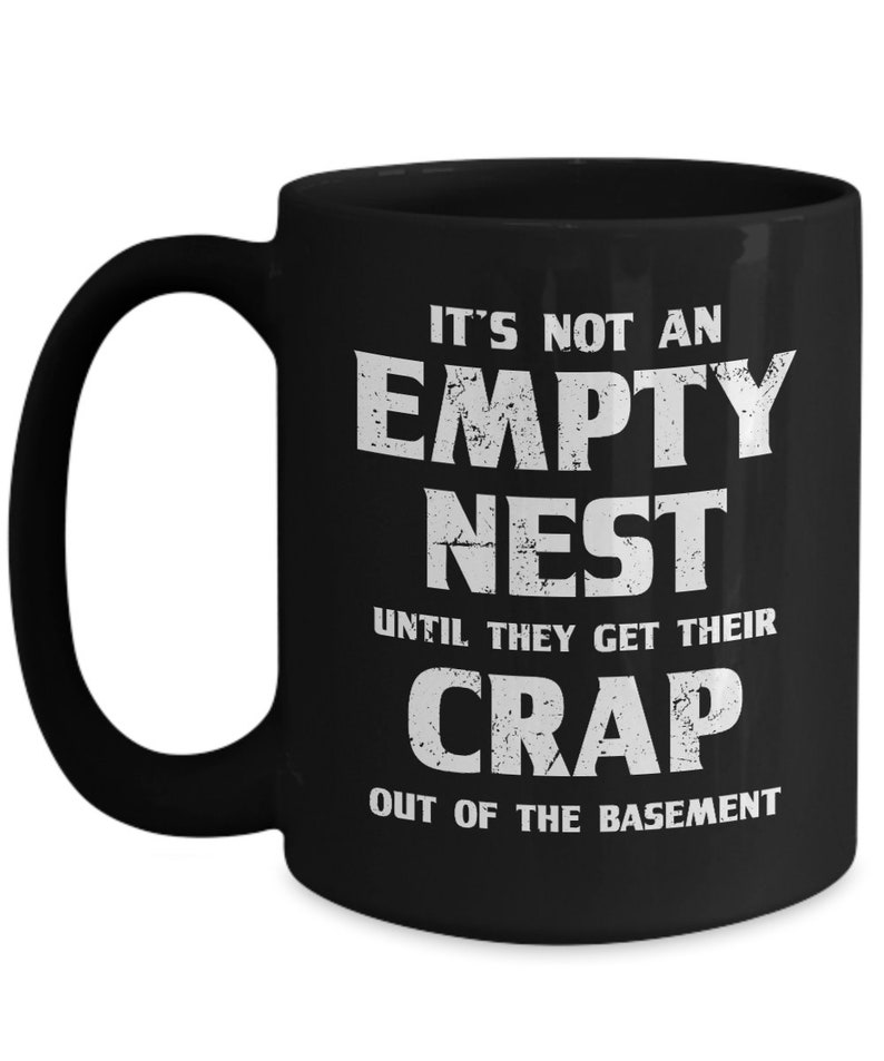 Pode incluir: Caneca de cer&acirc;mica preta com texto branco: "IT'S NOT AN EMPTY NEST UNTIL THEY GET THEIR CRAP OUT OF THE BASEMENT". A caneca tem uma al&ccedil;a grande.