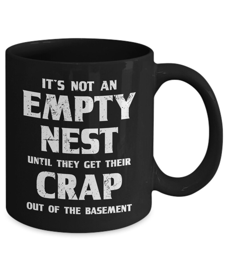 Pode incluir: Caneca de cer&acirc;mica preta com uma cita&ccedil;&atilde;o humor&iacute;stica branca: "IT'S NOT AN EMPTY NEST UNTIL THEY GET THEIR CRAP OUT OF THE BASEMENT." A caneca tem uma al&ccedil;a grande e &eacute; adequada para bebidas quentes ou frias.