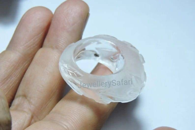 K&ouml;nnte beinhalten: Ein wei&szlig;er, durchsichtiger Ring mit einem geschnitzten Design. Der Ring ist aus einem Material, das wie Glas oder Plastik aussieht.