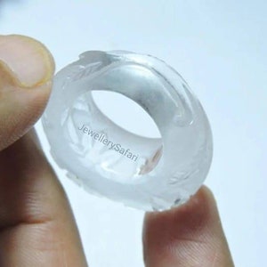 K&ouml;nnte beinhalten: Ein klarer, wei&szlig;er Ring mit einem detaillierten Design. Der Ring ist aus einem glatten, polierten Material gefertigt und hat ein schlichtes, elegantes Aussehen.