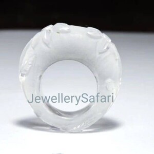 K&ouml;nnte beinhalten: Ein wei&szlig;er, geschnitzter Ring aus Quarz. Der Ring hat ein einzigartiges Design mit filigranen Details. Der Ring ist ein Statement-Piece und w&auml;re eine gro&szlig;artige Erg&auml;nzung f&uuml;r jede Schmucksammlung.