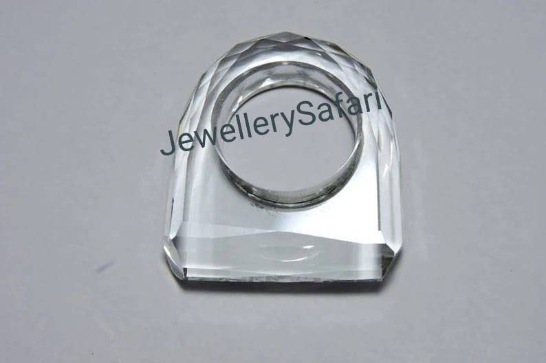Puede incluir: Un porta anillos de cristal transparente con un dise&ntilde;o facetado. El porta anillos tiene forma de anillo y tiene una gran abertura en el centro.