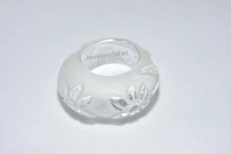 K&ouml;nnte beinhalten: Wei&szlig;er, gefrosteter Glasring mit Blumenmuster. Der Ring hat einen Durchmesser von etwa 2,5 cm.