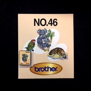 May include: A light peach-colored brochure with the text "NO.46" and the brand name "brother." The brochure features illustrations of a koala, a parrot, and a platypus. A small, clear plastic case holds a smaller version of the koala illustration.