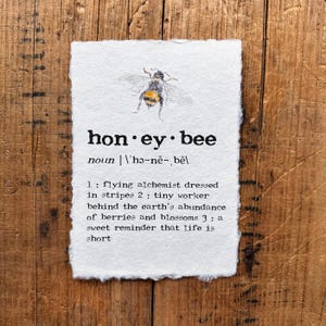 May include: A white paper print with the words "honey bee" and a watercolor illustration of a bee. The print includes a definition of "honey bee" with three descriptive points about the insect.