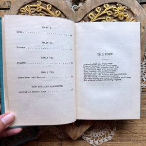 May include: An open book with a blue cover and white pages. The text on the page reads "The Poet" and includes a poem about a moody child who is wildly wise.