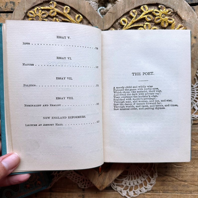 May include: An open book with a blue cover and white pages. The text on the page reads "The Poet" and includes a poem about a moody child who is wildly wise.