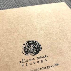 May include: A brown paper card with a black and white illustration of a rose. The text "alison rose vintage" and "alisonrosevintage.com" is printed on the card.