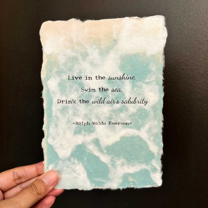 Pode incluir: Uma cita&ccedil;&atilde;o de Ralph Waldo Emerson em um fundo de papel texturizado azul claro e branco. A cita&ccedil;&atilde;o diz: "Live in the sunshine, Swim the sea, Drink the wild air's salubrity -Ralph Waldo Emerson- "