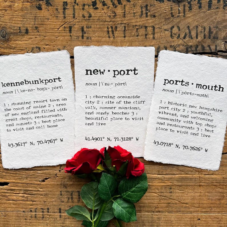 May include: Three white cards with black text describing the towns of Kennebunkport, Maine, Newport, Rhode Island, and Portsmouth, New Hampshire. Each card includes the town's name, a definition, and the town's geographic coordinates.