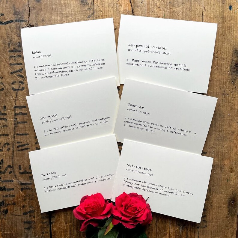 May include: Five white cards with black text defining words like "team", "appreciation", "inspire", "leader", "bad-ass", and "volunteer".