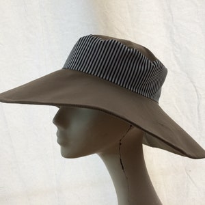 May include: A wide-brimmed sun hat with a brown crown and a black and white striped band.
