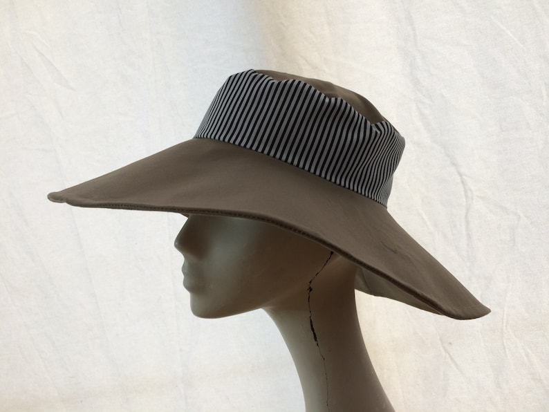 May include: A wide-brimmed sun hat with a brown crown and a black and white striped band.