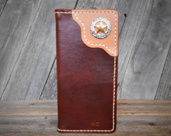 May include: A handcrafted leather wallet in shades of brown and tan, featuring a decorative silver and gold star emblem. The wallet has white stitching and a unique design, perfect for carrying cards and cash.