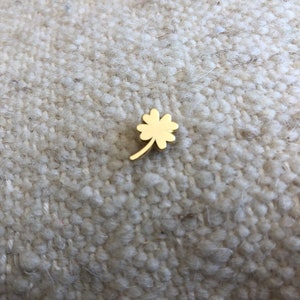 May include: A gold four-leaf clover charm.
