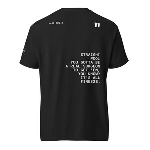May include: Black t-shirt with white text that reads "STRAIGHT POOL YOU GOTTA BE A REAL SURGEON TO GET 'EM, YOU KNOW? IT'S ALL FINESSE." The text "FAST EDDIE" is printed at the top. The shirt has a crew neck and short sleeves.