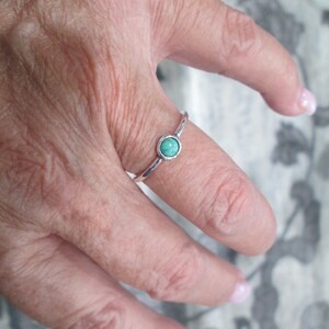 May include: A silver ring with a turquoise oval-shaped stone.