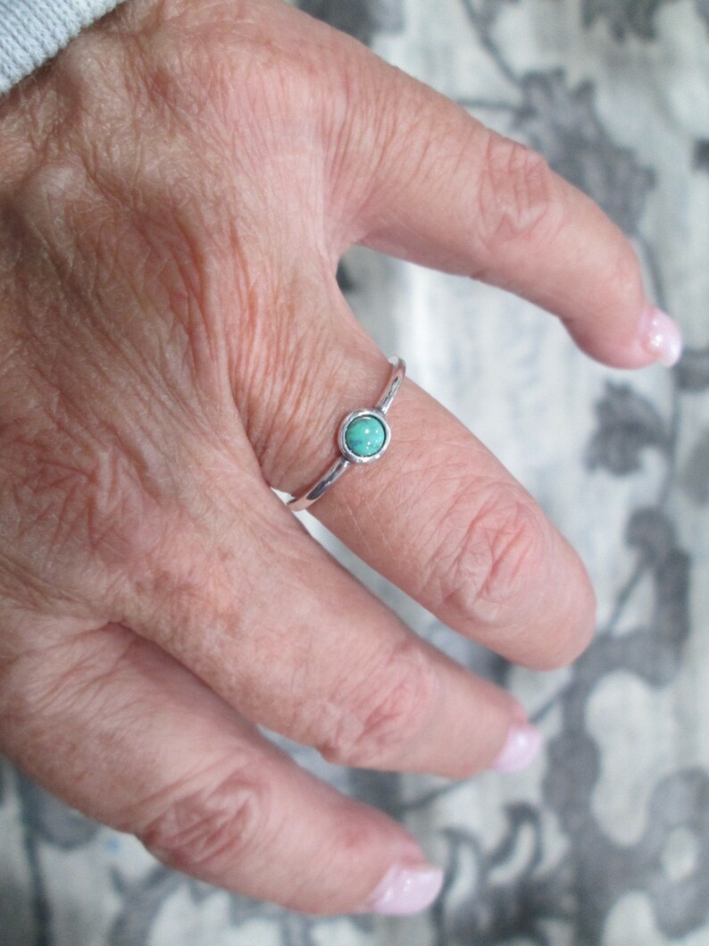 May include: A silver ring with a turquoise oval-shaped stone.