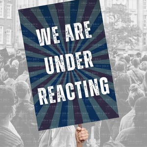 Puede incluir: Un cartel de protesta azul y blanco con el texto "WE ARE UNDER REACTING" en letras blancas. El cartel tiene un diseño radial con rayas blancas y azules.