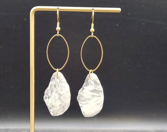 May include: A pair of gold hoop earrings with clear, textured, teardrop-shaped charms.