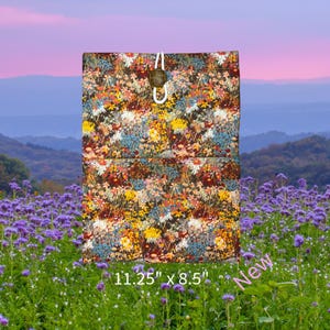 May include: A brown fabric tote bag with a floral print. The bag has a drawstring closure and a wooden toggle. The bag measures 11.25 inches by 8.5 inches. New.