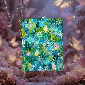 May include: A rectangular, fabric book cover with a vibrant floral pattern in shades of teal, green, and pink. It features a turquoise button closure and white string loop. The background includes butterflies and soft, blurred lighting.