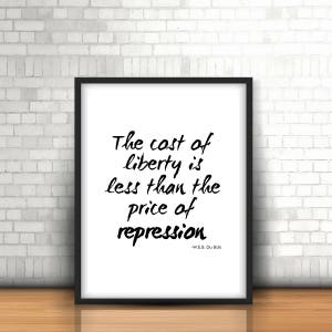 Peut inclure: Impression typographique en noir et blanc avec la citation "Le coût de la liberté est inférieur au prix de la répression" attribuée à W.E.B. Du Bois. L'impression est encadrée dans un cadre noir et est affichée sur un mur de briques blanches.