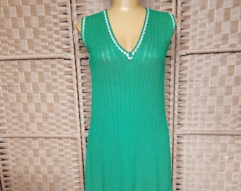 Puede incluir: Un vestido de punto verde sin mangas con ribete de crochet blanco alrededor del escote y el dobladillo.