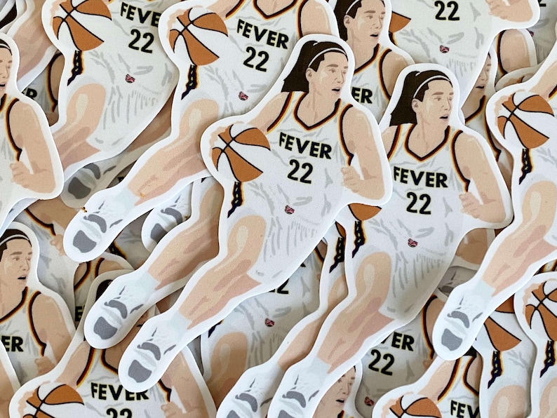 May include: A stack of white basketball player stickers with the text "FEVER 22" on the front. The player is wearing a white jersey with purple and orange accents. The player is holding a basketball.