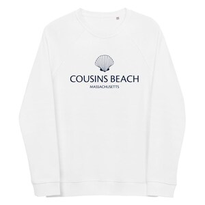 Peut inclure: Sweat-shirt blanc avec un motif de coquillage bleu marine et l'inscription "COUSINS BEACH MASSACHUSETTS". Le sweat-shirt a des manches longues et un col rond.
