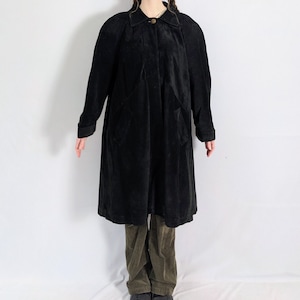 May include: A long black suede coat with a button fastening and two pockets.