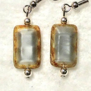 May include: A pair of silver dangle earrings with rectangular gray and brown glass beads.