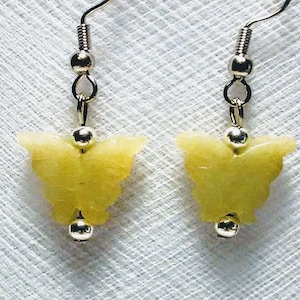 May include: A pair of silver butterfly earrings with yellow butterfly charms. The earrings are on a white background.