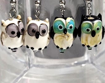 Owls in white has purple eyes and black with teal eyes earrings