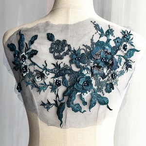 Puede incluir: Aplique de encaje floral azul turquesa con cuentas de perlas y lentejuelas sobre un tejido de malla transparente. Este adorno delicado es perfecto para agregar un toque de elegancia a la ropa, los accesorios o los proyectos de decoración del hogar.