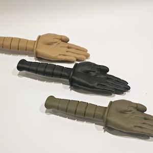 May include: Three training knives with different colored handles and hand-shaped blades. The handles are black, tan, and green.