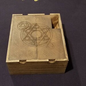 May include: A wooden box with a hinged lid. The lid has an intricate geometric design etched into the wood. The box is closed.