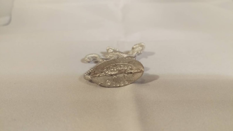 May include: Silver metal figurine of a knight on horseback. The base of the figurine has the inscription "Breyer 91584".